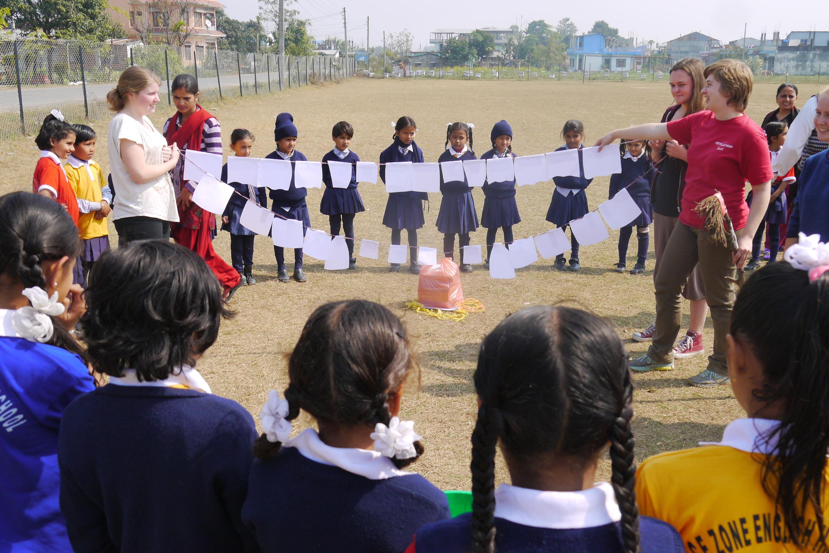 Childcare volunteers are demonstrating general hygiene to children in a workshop outside their school in Nepal. Projects Abroad volunteers working with children in Nepal are demonstrating how to brush your teeth in a school Childcare project.